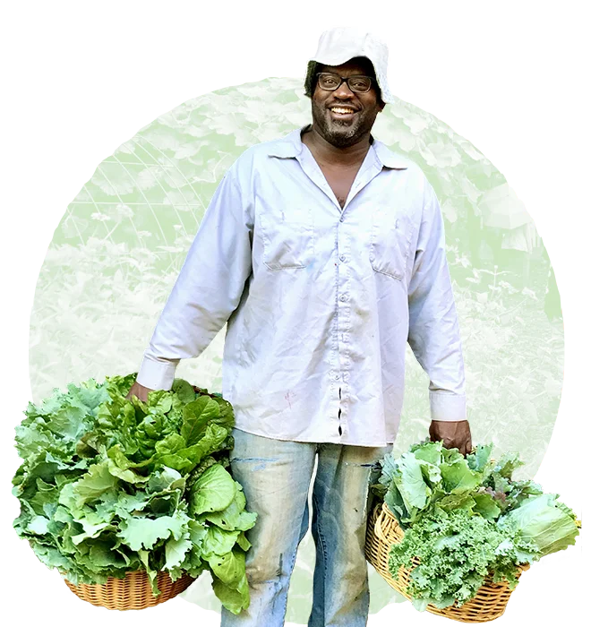 Co-Founder DeWayne Barton holding harvested greens from the garden